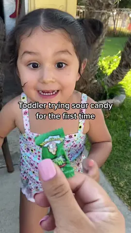 I got mixed signals here, but I think she liked it.🍏😆 my mom is always in the chisme 📞 #toddlertryingfood #toddlerreaction #warheadscandy  #sourcandychallege #fyp #sourcandyreview #PlutoTVIsFree