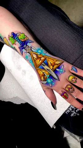 ✨🧝🏻‍♀️ Legend of Zelda hand and fingers set 🧝🏻‍♀️✨  Jeweled triforce, master sword and some korok friends having fun on the top 🍃 12 hours session, one sitting 🧚🏻‍♂️ #tattooprocess #lauraanunnaki #zeldatattoo