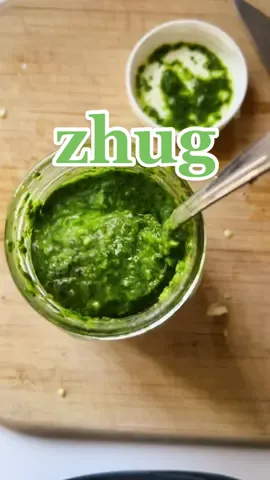 Zhug, a spicy and verdant Yemeni condiment meant to be crushed with a mortar and pestle. To get the most out of this condiment, I would highly recommend toasting and grinding your spices — cardamom pods, cumin seeds, and coriander seeds. In this version, I’m using preground spices from my spice cabinet and my handy food processor. #zhoug #zhug #hotsaucelovers #homemadecondiments 