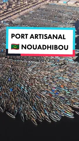 The Port Artisanal:  located in Nouadhibou, originally called Port-Étienne, during the colonial era, was originally the first African stopover of the Aéropostiale. the uniqueness of this port is in its ability to house hundreds of pirogues in a colourful puzzle-like pattern that is as beautiful as it is random. Filling the empty spaces of this incredibly evolving structure are the men and women who live and work here, fueling the synergy of arts and crafts in motion due to their constant and continuous movements. They say that more than 9000 boats battle for a spot in the port artisanal of Nouadhibou 🛶 🇲🇷|By: 🎥 @LucaOnAdventure #mauritania #travel #traveltiktok #nouadhibou #ocean #westafrica #saharadesert #africa #viral   #travelvideo #dronevideo  #beautiful_destinations #foryoupage #fyp #videooftheday 