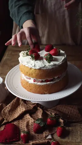Strawberry “Shortcake” Sponge Cake 🎂 🍓 One of you suggested that we make a strawberry shortcake for Valentine’s Day, and I loved the idea! Here is a romantic vintage version of a strawberry “shortcake” cake! 🍓 Did you know the term shortcake was coined by William Shakespeare? I didn’t either! It was the name of a character in “The Merry Wives of Windsor” and thus the biscuit dessert was named after him. 🤭 You can find the full recipe for this cake on our blog. Link in profile! ❤️ I am wearing the Jo Dress and Meg Apron from @littlewomenatelier - linked in profile!  #bakergirl #englishcottagestyle #cozyvibes #cozycottage #victorianhouse #victorianstyle #historybounding #littlewomen #cottagedress #slowsimpleseasonal #vintagecake #cakerecipe #spongecake #f52grams #onmycreativetable #dessertperson #fyp #baketok #caketok #cottagecore #cottagecorebaking 