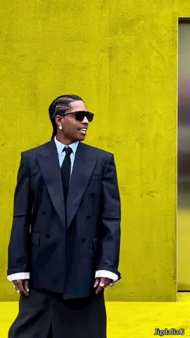 ASAP Rocky at the Gucci Fall/Winter 2023 Fashion Show In Milan. He wore a navy blue pinstripe jacket, white shirt, and classic black tie. He completed his look with oversized smoke-grey trousers that feature a double layered skirt. #asaprocky #gucci #fw23 #milanfashionweek  #milan #fashion #fashionweek 