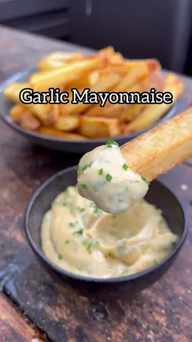 All about the Sauce, 43 of 50. My favourite Garlic Mayonnaise, warming and subtle in flavour but packing a bit savoury umami punch. Very addictive especially with salty chips/fries. 15 garlic cloves 250ml neutral flavoured oil so sunflower/vegetable/avocado etc 1 bay leaf Few sprigs of thyme Few sprigs of Rosemary  2 large egg yolks 1 tsp Dijon mustard Squeeze of lemon juice 1 heaped tsp white miso paste or 1 tsp salt Handful of flat parsley Few chopped chives 1. Gently cook the garlic in the oil with herbs for 45 mins, ideally around 80c. Strain off the oil and set aside to cook then remove the herbs their work here is done. 2. Crush the garlic cloves and set to one side 3. Add the egg yolks, mustard, lemon and miso or salt to a bowl and whisk. Stream in the garlic oil and whisk constantly until a mayonnaise forms  4. Add the garlic, parsley and chives. Season to taste with salt and lemon juice 5. Eat mayonnaise and be happy #sauce #sauces #cooking #Recipe #garlic 