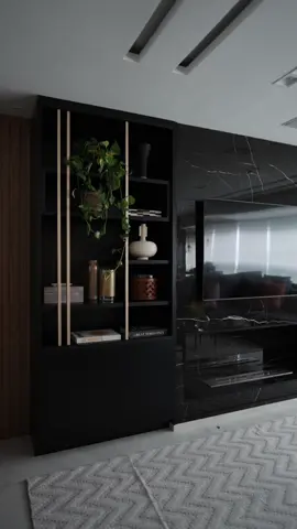 Sala de estar sofisticada em tons de preto e amadeirado, que contrastam no painel de TV. A marcenaria escura traz um toque elegante e personalidade ao espaço. Venha conferir cada detalhe desse conceito! Me conta aqui nos comentários qual parte dessa sala você mais gostou!!!👇🏻 #arquitetanotiktok #arquiteturadeinteriores #marianamaran #arquitetura #execucaodeobra 
