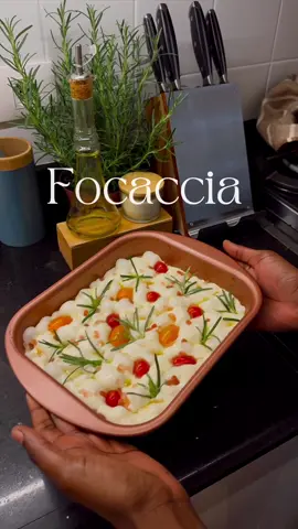 FOCCACIA 🤍 Ingredientes - 300g de farinha - 240ml de água  - 3g de fermento biológico fresco (ou 1g de fermento biológico seco) - 2 colheres de sopa de azeite - 6g de sal - Alecrim - Sal grosso  - E o que mais você quiser colocar por cima 🥰 MODO DE PREPARO Peneire a farinha e reserve. Misture o fermento fresco na água, coloque as colheres de azeite e em seguida misture com a farinha aos poucos. (Vai ficar molengo mas é assim mesmo, essa é uma massa muito hidratada) • Deixe descansar por 15 minutos (com algum prato ou tampa por cima) Acrescente o sal, e misture bem. • Deixe descansar por 15 minutos (com um pano por cima) Passe azeite nas mãos e faça dobras até ficar com a aparência lisa e tente moldar. NÃO SOVE. A forma de desenvolver o glúten desse pão é com as dobras e descanso, então respeite esse tempo (não dá pra fazer mais rápido que isso). Unte um bowl com azeite, coloque a massa nele e cubra com filme(faça furinhos como fiz no vídeo) e um pano. • Deixe descansar por 1 hora e meia Unte uma forma com azeite e faça mais algumas dobras na massa e depois leves movimentos para espalha-la, SEM RASGAR. Coloque um pouco de azeite por cima e cubra novamente com o filme. • Deixe descansar por 40 minutos Faça furinhos na massa com as pontas dos dedos untados de azeite, para não grudar. Adicione alecrim, sal grosso e mais o que você quiser. Aqui eu coloquei tomatinhos cereja e regue bem com azeite. Leve ao forno pré aaquecido a 240 graus. Aqui eu fiz assim:  - 15 min na grelha de baixo - 15 min na parte de cima (Claro que isso também vai depender do seu forno, então fique acompanhando se for sua primeira vez) Deixe esfriar e corte. A ideia é que ele fique crocante por fora e macio por dentro com bolinhas (sinal que o glúten desenvolveu bem e o pão ficou com ar ou seja BEM LEVINHO E FOFINHO) Pode servir com manteiga de ervas ou geleia. Tudo fica bem com focaccia 😍 BOM APETITE! E se fizerem por aí, me marquem 🥰 #focaccia #bread #food #reels #explore  #pao  
