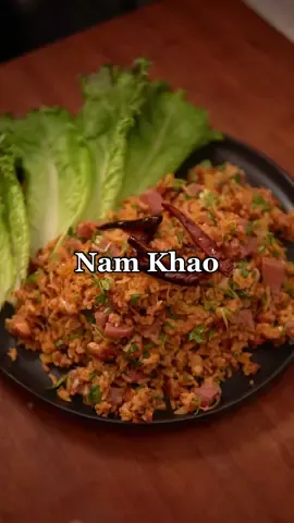Nam Khao(Inspired by @Saeng ) Ingredients * 2 cups rice * 2.25 cups water * 1 egg * 1/4 cup red curry paste * 1 tsp chicken powder or msg * 1 tbsp sugar * 1 cup shredded coconut * 1 tbsp kaffir lime leaves(minced) * 2 tbsp fish sauce * Lime juice(start with 1 lime and add more to taste) * 1 cup som moo(fermented pork) * 1/4 cup shallots(sliced) * 1/2 cup green onion(sliced) * 1/2 cup cilantro(chopped) * 1/4 cup roasted peanuts * Lettuce * Dried Thai chillies Instructions 1. Rinse rice with water until water runs clear then drain the water, add fresh water, and cook in a rice cooker. Let the rice cool down to room temperature. 2. Combine egg, red curry paste, chicken powder, and sugar. 3. Add mixture to the cooled down rice along with shredded coconut and kaffir lime leaves. 4. Form disk shaped rice balls(about 8 balls) and deep fry them at 350ºF until golden brown and crispy(3-5 minutes). 5. Let the rice balls cool down and deep fry dried chillies for about a minute until it turns a deep red color. 6. Break up the rice balls and add fish sauce, lime juice, som moo, shallots, green onion, cilantro, and roasted peanuts. Normally, you would add shredded pork skin but I couldn’t find it. 7. Serve with lettuce and garnish with the fried dried chilies.  #mygfwascraving #Recipe #cooking #datenightidea #namkhao #crispyrice #laos #laofood #EasyRecipe #recipetutorial #food 