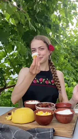 Мамалига 🇲🇩 Мамалига - це не просто кукурудзяна каша, це страва з багатьох компонентів, де кожна складова доповнює одна одну. Кількість порцій - 4 Час приготування - 1 година Інгредієнти: ✅ Кукурудзяна крупа - 200 г ✅ Вода - 600 мл ✅ Сіль - дрібка  ✅ Вершкове масло  ✅ М’ясо (в мене свинина) - 400 г ✅ Цибуля - 1 шт ✅ Болгарський (або Капі) перець - 1 шт ✅ Сіль, перець - за смаком  ✅ Вода - 50-100 мл ✅ Олія - для обсмаження  ✅ Яйце - 2 шт ✅ Вершкове масло (або олія) ✅ Сметана - по бажанню  ✅ Сіль  ✅ Часник - 4-5 зубчиків  ✅ Сіль - 0,5 ч.л. ✅ Олія - 1 ст.л. ✅ Бульйон або вода - 2 ст.л. ✅ Бринза (тверда і солона) ✅ Сметана  Приготування: 1. В казанок (або кастрюлю з антипригарним покриттям), наливаємо воду, солимо і вмикаємо вогонь. 2. Коли вода майже закипить, зменшуємо вогонь на мінімум і повільно, постійно помішуючи всипаємо кукурудзяну крупу.  3. Коли каша трохи загусне, додаємо вершкове масло та продовжуємо мішати. 4. Накриваємо казанок кришкою на 20-25 хвилин, але кожні 5 хвилин відкриваємо і помішуємо нашу кашу. 5. Після вимикаємо вогонь і залишаємо кукурудзяну кашу настоятись (якщо раптом в вас крупа не дрібного помолу, то вам знадобиться трохи більше води і часу на приготування). 6. Наступний компонент - це токана. Вона може бути, як овочева, так і м’ясна. 7. Гарний шматочок підчеревка нарізаємо кубиками, обсмажуємо до золотистості, потім додаємо цибулю, перець, сіль, перемішуємо, додаємо трошки водички і тушкуємо до готовності. 8. Далі робимо яєчню-бовтанку. Яйця обсмажуємо на вершковому маслі і по бажанню можна додати трохи сметани. 9. Останній компонент - це молдавський соус «Муждей». Нарізаємо часник, трохи перетираємо з сіллю, потім додаємо олію, бульйон (або водичку), добре перемішуємо. 10. Натираємо бризу на терці. Кукурудзяна каша, бринза, яйця, м‘яско, часниковий соус та сметана - ось що таке справжня молдавська мамалига! Всім смачного!