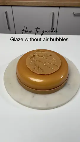 How-to guide: Glaze without air bubbles!   Do you know the feeling of having prepared a cake, you juuust need to finish it off by glazing, and then there’s air bubbles in the glaze 🤦🏼‍♀️  The most annoying feeling haha 😅 However, it’s easy to avoid once you know the trick 🤍 Follow these steps to always get a perfect glaze without air bubbles: 1. Pour the liquid over the chocolate in the pitcher. 2. Tilt the pitcher and put the hand blender down at an angle. Make sure you don’t put it down straight as this is what create the air bubbles  3. Place the hand blender on the edge of the pitcher as a support for yourself. It makes it easier to know how much at an angle the blender should be and makes the blending more stable. 4. When adding colour to the glaze, leave the blender straight in the pitcher without ever lifting it above the glaze, add colour, place the blender on the edge of the pitcher again, and blend. 5. Put cling film on top of the glaze and stir it once in a while until it’s cooled to approx. 35 degrees (depending on which recipe you’re using).  If you stir the glaze too much without the cling film on, it’ll also create air bubbles, so only remove the cling firm right before you’re ready to glaze. 6. Remove air bubbles from the top of the glaze with a small rubber spartula. 7. Now you’re ready to glaze without any air bubbles!  You would like the glaze recipe? Let me know in the comments 🩷      #howto #stepbystep #pastrychef #mirrorglaze #glazecake #caketutorial #cakedecorating #cakedesign #pastry #cakeart #patisserie  