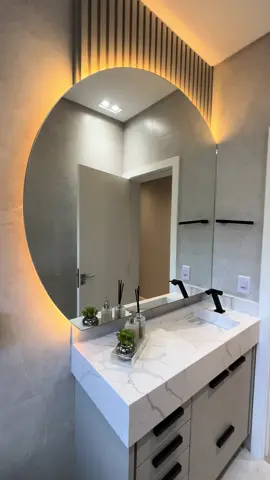 A harmonia entre os elementos desse projeto é o que o torna deslumbrante 🖤 A imponência das ferragens em preto contrasta com a serenidade do MDF claro e da iluminação em tons quentes, compondo assim um visual bem contemporâneo e cheio de charme.    Alto padrão de móveis sob medida para gostos exigentes: entre em contato conosco através do link na Bio. 📲 #banheirodecorado #banheirosobmedida #banheiromoderno #banheirosocial #banheiroplanejado 
