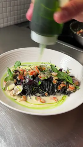 Episode 35 | How to keep her wet for more. #pasta #Foodie #cooking #yummy #seafood  Beautiful, rich, creamy seafood pasta with prawns, chillies, garlic, lemon, and parsley – finish with a creamy Vongolo mussel veloute, parsley oil, and micro herbs.  Serves 2 Cutie Pies (plus a touch extra in the case for a three-way) Difficulty - Medium Before you begin:  1. Great seafood dish if you like your pasta creamy.  2. You can opt for store-bought squid ink pasta to save time.  3. For additional details, see my recipe site.  Parsley Oil: - 200g grapeseed oil  - 20g Parsley Blanche parsley for 30 seconds. Cool down in ice water. Pat dry and blend with oil until bright green. Strain over muslin cloth (Note: Makes extra).  Squid Ink Semolina Noodles: - 130g Semolina Flour  - One egg - One egg yolk - 1 tsp olive oil  - Pinch of sea salt - 4g squid or cuttlefish ink Mix until a smooth and elastic dough forms. Refrigerate to allow the dough to relax before shaping into desired pasta shapes, i.e., noodles.  Vongolo Mussel Voulette:  - 125g Vongolo mussels (keep 10 for garnish, rest for sauce) - A generous splash of white wine with Vongolo mussels - A touch of neutral oil - 60g of fish stock - 60g chicken stock - 35g of white wine - 35g white vermouth  - 300g of double cream Cook mussels with white wine. Discard any unopened or broken ones. Strain and collect juice. Reserve 10 for final plating. For the remaining, pick the meat and discard the shells—caramelised, lightly picked mussel meat. Add fish, chicken, white wine, and vermouth – reduced 2/3rds. Add cream and reduce to a little below 1/2. Keep warm when ready for use. Base Sauce (Prawns, Garlic, Chilli, Parsley, Lemon: - A generous splash of neutral oil - 150g mini prawns, finely diced - 2-3 small chillies finely diced  - One small garlic clove finely minced - 10 reserved Vongolo mussels - A generous splash of white wine - Small handful of finely chopped parsley  - Al dente Squik Ink Noodles - 1/3 juice of a lemon - S&P to taste Sautee prawns, followed by chillies and garlic. Add reserved Vongolo mussels. Add white wine to reduce, followed by parsley and squid ink noodles. Add lemon juice and season to taste.  Finishing Touches: - Prepared & Warm Vongolo Mussel Voulette - Parsley Oil - Micro Herbs (optional)  Add the remaining ingredients to complete the dish, and enjoy. 
