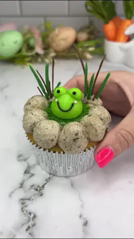 A frog in a pond 🐸🩷 Bringing back my jelly cupcakes 🩵 who remembers them?🤘🏻🐸 I used Oreo buttercream for the pebbles and chilled the cupcake before adding the jelly. I added some edible glitter to make it sparkle. I let the jelly set before I added the frog. The reeds are made from chocolate 🍫  #cupcake #jellycupcakes #frog #cakeart #cakedbyrach #cutefood #cupcakedecorating #caketok 