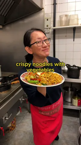 Recipe on how to make Chinese takeaway style crispy noodles with vegetables (shū cài zhá miàn) below. I love how crispy the noodles are on the outside but then coated with delicious vegetables and gravy makes the noodles in the middle super soft. This dish reminds me of happy takeaway memories, I loved watching mum make this one for customers as a kid, it was so satisfying to watch the noodles get deep fried in the oil (it’s the small things that count). It’s also a beautiful dish to plate up IMO ❤️‍🔥 📍 Wok Inn, Sheffield (S12 3DZ) 1 portion of 100g thick egg noodles (we used classic takeaway brand - lucky boat no.1) / you can also use cooked egg noodles from your local shop For blanching the veg: 1 small broccoli head (split into florets) 1/2 carrot (sliced) 7 mangetout  3 mushrooms (chopped) 5 pak choi leaves 2 tbsp veg oil For stir frying the veg: 1 tbsp garlic (minced) 1/4 large onion (sliced) 1/2 courgette (thinly sliced) 1/4 red pepper (sliced) 6 Chinese straw mushrooms 5 tbsp veg oil For the sauce: 1 heaped tbsp cornstarch mixed with 2 tbsp of water (cornstarch slurry) 2 tbsp vegan oyster sauce  2 tbsp vegetable powder 2 tbsp light soy sauce  1 tbsp dark soy sauce  1 tbsp shaoxing wine 1 tsp sugar, white pepper, sesame oil and salt 150ml water Bring a large pot of water to boil then add to your lucky boat egg noodles and cover for 18 mins. Strain when cooked through. Meanwhile, bring a wok of water to boil on medium-high heat, add vegetables for blanching and 2 tbsp of oil. Blanch for just two mins then set aside. On medium-high heat add 5 tbsp of oil to a wok along with the garlic and onions. Stir fry for one min until lightly golden then add the vegetables for frying and fry for another two mins.  Add the ingredients for the sauce to the wok along with your cornstarch slurry and mix well for just 2 mins.  Deep fry your noodles in a wok of oil at around 160c for just 1 min then set aside. Pour your vegetables and gravy gravy over the noodles and enjoy. #chinesetakeaway #crispynoodles 