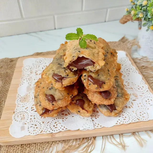 Assalamualaikum.. kali ini umi bikin cemilan simpel yg uenak.. garing renyah kriuk, trs dalemnya kosong, legit, ada isian coklat lumer didalamnya..yummiii.. Wajib coba gaes..👍👍 Vidio lengkap cek yt Annisaa Hawarizmi ya PISANG GORENG NAGA (Modifikasi resep The Hasan Vidio) 200 g tepung terigu pro rendah 100 g tepung beras 30 g tepung maizena 20 g tepung tapioka 1 sdt penuh BP DA 1 butir telur utuh 35 g margarin leleh 450-500 mL Air 15 g wijen hitam ½ sdt pasta vanilla 1 sdm gula pasir (optional) #pisanggorengnaga #pisangkopongisicoklat #pisanggoreng #olahanpisang #reseppisanggorengnaga 