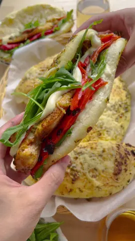 PESTO BREAD WITH CHICKEN #pesto #Recipe #food #chicken #bread #tiktokfood #fy #fyp #foryou #foryoupage #kookmutsjes DOUGH 500 g flour (all-purpose) 40 g Parmesan cheese 40 ml olive oil 10 g instant yeast (dry yeast) 12 g honey 8 g salt (1⅓ teaspoons) 280 ml water (lukewarm) 50 g fresh pesto 75 g grated cheese CHICKEN MIXTURE 550 g chicken breast 4 g salt (⅔ teaspoon) 3 g onion powder (1 teaspoon) 3 g garlic powder (1 teaspoon) 3 g red bell pepper powder (1 teaspoon) 1.5 g cayenne pepper powder(½ teaspoon) 1.5 g dried parsley 25 ml olive oil GARNISH 50 g fresh pesto mozzarella grated cheese tomato Place the flour, Parmesan cheese, olive oil, yeast, honey, salt, and lukewarm water in a large bowl. Mix and knead the dough for 10-12 minutes. Cover the dough and let it rise in a warm place at home for 1 hour, or until it has doubled in size. Wash the chicken and cut it into flat pieces. Put the chicken in a large bowl along with the salt, onion powder, garlic powder, red bell pepper powder, cayenne pepper powder, dried parsley, and olive oil. Mix well and place the bowl, covered, in the refrigerator. Divide the dough into 6 equal pieces and shape them into balls. Take one ball of dough and roll it out flat. Fold it in half. Place the dough on a baking sheet lined with parchment paper. Spread a layer of green pesto and grated cheese over it. Let the dough rise for 30 minutes, or until it has doubled in size. Preheat the oven to 200℃ (390 . Bake the bread for 10-15 minutes, or until they are golden brown. Spread the chicken on a baking sheet lined with parchment paper. Place the chicken in the preheated oven at 200℃ and bake for 15 minutes. Carefully remove the chicken from the oven. Spread a layer of green pesto on the chicken and top with grated cheese, mozzarella, tomato slices, and more grated cheese. Place the chicken back in the preheated oven at 200℃ and bake for another 10 minutes. Open the pesto bread and fill it with some sauce, fresh vegetables, grilled red pepper, mozzarella, and the chicken-pesto mixture or other ingredients to taste.