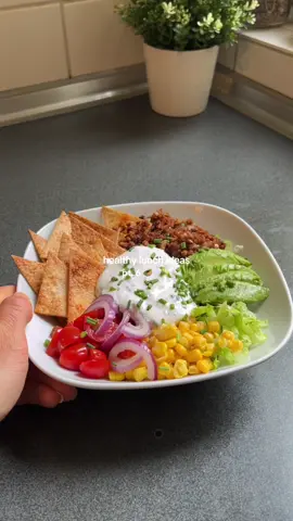 Veggie Nacho bowl - healthy and satisfying lunch idea 🥑✨ Ingredients: Tortillas: - Tortillas, cut into triangles - Vegetable oil or cooking spray - Salt, pepper, paprica Sour cream:  - 1 cup plain yogurt - Juice of 1 lime - Salt and pepper to taste Nacho Bowl: - Vegetable oil (for frying) - veggie minced meat - 1 tsp paprika, 1 tsp chili powder, Salt and pepper to taste - Grated mozzarella cheese - Iceberg lettuce, chopped - 1 cup corn kernels (cooked) - 1 cup cherry tomatoes, halved - 1/2 red onion, thinly sliced - 1/2 avocado, sliced - Chopped chives #VeggieNachoBowl #PlantBasedEating #VeggieRecipes #HealthyEating  #Nachos #VeggieDinner #EasyRecipe #healthyfood #lunchidea #FoodTok