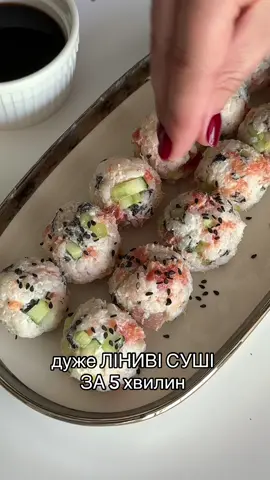 ЛІНИВІ СУШІ за 5 хвилин!🥢 @СМАЧНІ РЕЦЕПТИ    Якщо любите суші, але лінуєтесь готувати, то цей рецепт для вас♥️ 🛒Всі необхідні інгредієнти можна купити у @Сільпо  ІНГРЕДІЄНТИ: ✅100 г рису для суші ✅110 мл води ✅для заправки: 15 мл яблучного оцту + 1 ч.л. цукру + 1/2 ч. л. солі або краще рисовий оцет для суші. ✅100 г слабосоленого лосося  ✅100 г вершкового сиру Philadelphia  ✅1 лист норі ✅100 г огірка ✅ кунжут - для подачі ✅соєвий соус  ПРИГОТУВАННЯ: Рис ретельно промиваємо водою декілька разів до прозорої води. Заливаємо його чистою водою та доводимо до кипіння. Ставимо вогонь на мінімум і варимо 15 хвилин, не піднімаючи кришку.  Після цього вимикаємо вогонь та даємо рису постояти ще 15 хвилин під кришкою. Додаємо заправку та перемішуємо. Нарізаємо в рис норі , рибку, огірок, додаємо Philadelphia та знову перемішуємо. Формуємо кульки та викладаємо на тарілку. Смачного!