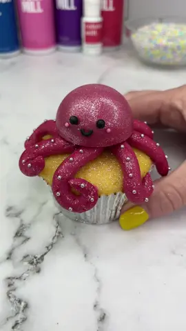 Sparkly octopus  cupcakes 🐙🧁 I used colourmill raspberry chocolate drip to fill my silicone cake pop mold. When set I brushed it with pink lustre dust. I coloured my buttercream with colour mill raspberry oil blend. I used piping tip 12 for the arms and sprinkles for the eyes and smile. 🐙✨ How cute 💕🐙 #cupcake #cupcakedesign #cakedbyrach #octopus #cakedesign #cutebaking #caketok  