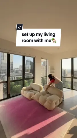 Decorate my living room in my new apartment with me.🤗 I'm extra proud of all my thrifted finds and how good they look in this space.✨ Still need to put some art up and currently DIYing a few pieces, but l'm loving how bright and open everything feels here.☀️ How much do we love this pink @Ruggable LLC rug here?! #homedecor #interiordesign #apartmentdecor #highrise #interior #interiorinspiration #modernapartment #livingroomdecor