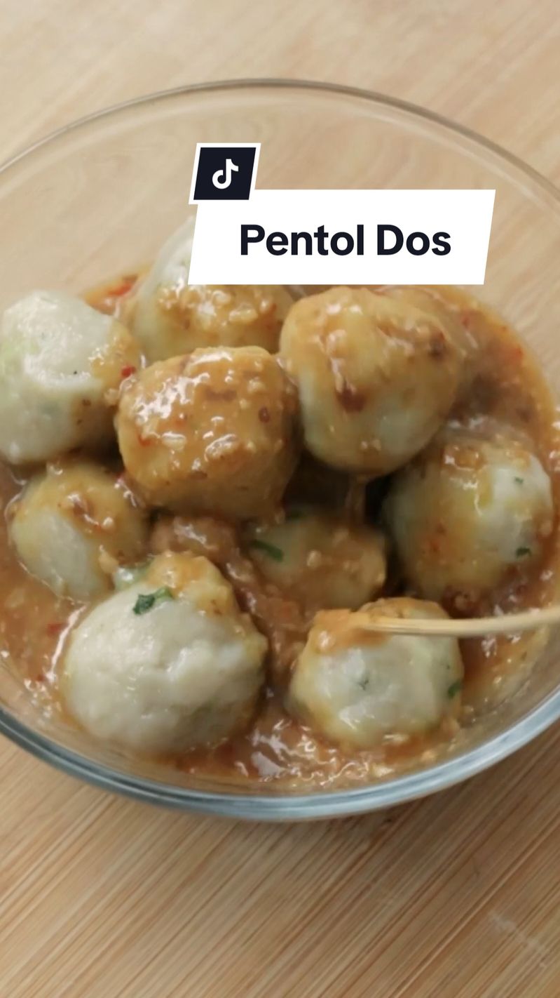 Resep Pentol Dos (untuk 70-80 pcs) Bahan biang: 5 siung bawang putih 5 siung bawang merah 50 ml minyak 350 ml air 120 gr tepung beras 1 sdt garam ¼ sdt merica 1 sdm kaldu ayam bubuk 1 sdt penyedap 1 sdm gula pasir 3 sdm kecap asin 2-3 batang daun bawang, cincang Bahan campuran adonan: 1 butir telur ayam 250 gr tapioka 50 gr tepung terigu protein sedang Pelengkap: jeruk limau sambal kacang Cara membuat : 1. Masukkan bawang putih dan bawang merah ke dalam food processor, haluskan 2. Panaskan minyak, tumis bawang putih dan bawang merah hingga sedikit kecokelatan 3. Campurkan air dengan tepung beras, aduk rata lalu masukkan ke dalam wajan 4. Masukkan garam, penyedap, kaldu ayam bubuk, gula pasir dan merica, masak hingga mengental dan matang kemudian pindahkan ke dalam mangkuk 5. Setelah adonan biang dingin, masukkan telur, kecap asin, terigu dan tapioka, aduk hingga rata 6. Cincang daun bawang dan campurkan ke dalam adonan, aduk rata. Bentuk bulat adonan kemudian rebus hingga mengapung dan matang, tiriskan dan tambahkan sedikit minyak 7. Tusukkan pentol dengan tusuk sate kemudian goreng hingga kering, tiriskan 8. Pentol dos siap disajikan