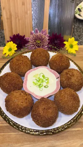 Loaded Mashed Potato Fritters🥔🧀 #Recipe #potatoes #cooking #food  Start out by washing and peeling 3 pounds of Russet potatoes.  Dice them up, then add them to a pot and submerge them in water.  Season the water with a generous amount of salt or chicken bouillon powder.  Let these boil for about 15 minutes (or until fork tender.) When they’re done mash them up in a large bowl, (I always use a potato ricer.) Once they’re completely cool, add: -3/4 pound of crumbled crispy bacon  -1/2 cup of sliced green onion -1/2 cup of sour cream -2 tablespoons of melted butter  -1 whisked egg -season with: garlic powder, smoked paprika, chicken bouillon powder, and salt and pepper.  Mix it all together until nice and smooth.  Then get an 8 ounce block of mild cheddar cheese and cut it into 21 cubes.  Measure out about 4 tablespoons of the potatoes, roll it into a ball, smash it into a patty, add a cheese cube to the center, then form the potatoes around the cheese and roll it back into a ball.  Let these sit in the fridge for no less then 1 hour.  Then add flour to one bowl, and in another bowl add 1 part regular breadcrumbs and 1 part panko.  Season both generously with the same seasonings used in the potatoes.  Then dip each one into the flour, then the whisked egg, and pack on the breadcrumbs. Then dip it back into the egg and then back into the breadcrumbs for a double coating.  Deep fry them in high heat oil (heated to about 330 degrees) until they’re golden brown letting them rest on a cooling rack.    ***Note: make sure to bread them straight from the fridge and fry them right away so that they maintain the correct temperature.  Then right before serving, put them in the oven at 350 degrees for 10 to 15 minutes or until the cheese is melted on the inside. Make sure to not over heat them because the cheese can start bubbling out.  Serve them right away with sour cream or ranch dressing for dipping.  Enjoy💜