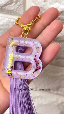 A delicadeza do lilás e das letras douradas, resulta em uma das peças mais pedidas aqui na Delicata 💜✨ #resina #resin #resinaepoxi #resinart #coisasderesina #coisasfeitasamao #videosatisfatorio #chaveirocomnome #chaveiro #flornaresina #letrasdouradasnaresina #chaveiroderesina 