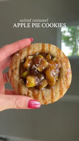 SALTED CARAMEL APPLE PIE COOKIES  Your apples called 🍎📞 Recipe below OR go to my website through the link in my bio 🤎  #Recipe Details (12-15 cookies): Apple Pie Filling: - 3 apples, chopped (and peeled if desired) - 1/4 cup brown sugar - 2 tbsp salted butter - 2 tbsp maple syrup - 1 tbsp cornstarch - 1 tsp cinnamon Cinnamon Vanilla Sugar Cookies: - 2 cups all-purpose flour @Bob’s Red Mill  - 3/4 tsp baking powder - 1/2 tsp baking soda - 1/2 tsp cinnamon - 1/2 tsp salt - 1/2 cup salted butter, at room temperature - 1 cup powdered sugar - 1 egg, at room temperature - 1/4 cup avocado oil (or another neutral oil) @Chosen Foods  - 1 tbsp vanilla extract  - 1/2 cup granulated sugar + 1 tbsp cinnamon, for coating Salted Caramel: - 3 tbsp coconut oil, melted - 1/4 cup smooth almond butter @Jem  - 1/4 cup + 3 tbsp maple syrup - Pinch of salt Instructions: Preheat the oven to 350F. Line two baking sheets with parchment paper; set aside. Start by preparing the apple pie filling. In a medium saucepan over medium heat, melt the butter. Add the chopped apples, brown sugar, maple syrup, cornstarch, and cinnamon. Heat until the mixture starts to bubble. Then, stir and cover and allow to cook for 5 minutes. Stir again and then remove from the heat once the mixture is thickened and the apples are soft. Set aside. Prepare the salted caramel. Combine all of the ingredients for the salted caramel in a medium bowl. Mix until smooth. You can add more maple syrup to get your desired consistency, if needed. Prepare the cinnamon vanilla sugar cookies. In a medium bowl, whisk together the flour, baking powder, baking soda, cinnamon, and salt. In a separate large bowl, cream the butter and powdered sugar until light and fluffy. Add in the egg, avocado oil, and vanilla. Beat until combined.  Add the dry ingredients to the wet, and mix until just combined.  Mix together the granulated sugar and cinnamon in a small bowl. Use a large (3 tbsp) cookie scoop to scoop cookie dough balls, and roll each ball into a circle. Drop and roll the dough balls in the cinnamon sugar, then place on the prepared baking sheets.  Use a 1/8th measuring cup or the bottom of a small jar to press a circle into the middle of each cookie.  Bake at 350F for 8-9 minutes. Remove from the oven, press the measuring cup back into the hole, and bake for another 1-3 minutes until the edges are golden.  Cool the cookies. Fill each hole with the apple pie filling, and then drizzle with salted caramel. Enjoy! #saltedcaramel #applepie #cookies #cookie #applepiecookies #applecookies #homemade #homemadeapplepie #homemadecookies #cookierecipe #fallbaking #falldessert #fallcookies #cozy #cozyrecipe #cinnamon #cozycookies @From Our Place @Earlywood @KitchenAid 