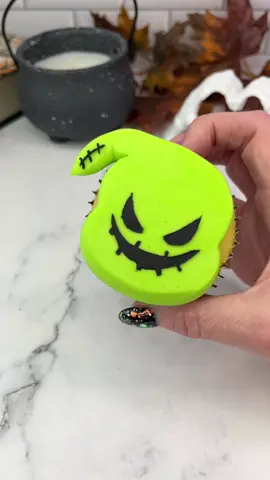 Oogie Boogie cupcakes 💚🖤 The Nightmare before Christmas time is here 💚🖤 Who’s your favourite character?  💚 Use a large round piping tip (ateco 809) to add  green buttercream for the face. I added the pointy part of the hood using piping tip 2A.  💚 Press the buttercream down onto parchment paper to achieve a flat surface. I shaped the point with a small metal spatula here to make it look neater.  💚 Freeze the cupcake for 15 minutes.  💚 Remove the parchment paper and attach your stencil to the top. I made the stencil using a square of parchment paper,l and a sharp blade.  🖤  Apply a thin layer of black buttercream over the stencil. Then carefully peel it off.  💚 Add some extra stitching to his hood.   #cupcake #cakeart #cakedecorating #nightmarebeforechristmas #oogieboogie #halloweenbaking #halloween #spookyseason #cakedbyrach 