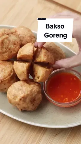 Resep Bakso Goreng (untuk 14-20 pcs) Bahan minyak kulit ayam: 100 gr kulit ayam 3 sdm air 45 ml minyak goreng 7 siung bawang merah iris Bahan adonan bakso: 400 gr paha ayam giling 100 gr udang kupas 5 siung bawang putih 1 sdt garam 1 sdt kaldu ayam bubuk 1 sdt penyedap 1 sdm gula pasir ¼ sdt merica 100 gr air es 200 gr tapioka 35 gr tepung terigu protein sedang 1 butir telur 1 sdt baking powder 2 sdt minyak wijen Pelengkap: saus cocolan Cara membuat: 1. Untuk minyak kulit ayam, panaskan wajan, masukkan kulit ayam dan air, masak hingga sedikit menyusut lalu gunting-gunting, masak hingga menyusut 2. Masukkan minyak goreng, masak hingga setengah kering lalu masukkan bawang merah, masak hingga kering dan kecokelatan 3. Di dalam food processor, masukkan minyak kulit ayam, bawang putih, setengah bagian paha ayam giling, garam, kaldu ayam bubuk, gula pasir, penyedap, merica, baking powder, minyak wijen, telur dan air es, haluskan hingga benar-benar halus dan teksturnya lengket 4. Masukkan sisa paha ayam giling dan udang. Aduk kembali sesaat 5. Pindahkan ke mangkuk kemudian masukkan tapioka dan terigu, aduk rata 6. Panaskan minyak, bentuk bulat bakso lalu goreng sekitar 25 - 30 menit atau hingga matang, angkat dan tiriskan 7. Bakso goreng siap disajikan