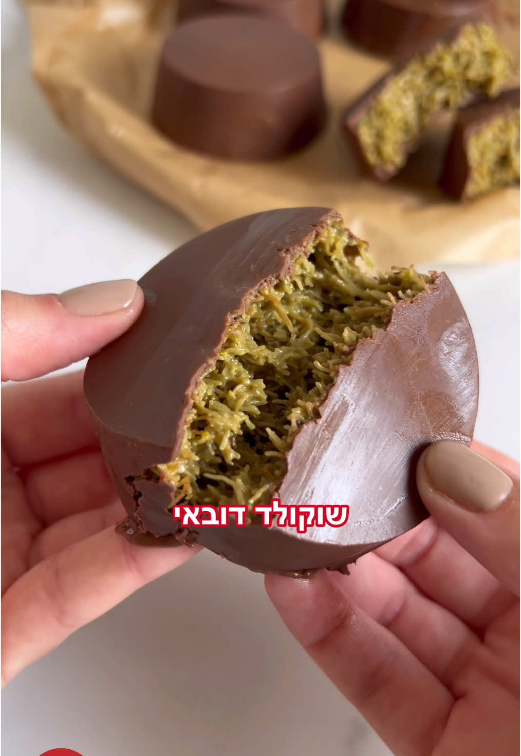 יש לנו תחושה שהאורחים שלכם בסוכה יבקשו מכם את המתכון אחרי ביס אחד 🤭🍫  מתכון לשוקולד דובאי  מצרכים ל10 עיגולים: 200 גרם שערות קדאיף 75 גרם חמאה  200 גרם פיסטוקים  3 כפות שמן  2 כפות טחינה גולמית 2 כפות אבקת סוכר  250 גרם שוקולד חלב  אופן ההכנה: קוצצים את שערות הקדאיף. מטגנים אותן על בסיס חמאה, עד להזהבה, בערך 15-20 דקות. בזמן הזה טוחנים את הפיסטוקים עם שמן עד לקבלת מחית (בהתחלה יהיו פירורים, ולאט לאט זה השומן ישתחרר ותווצר מחית) - ניתן להשתמש גם במחית קנויה (אותה כמות). לאחר שהקדאיף מטוגן, מערבבים בקערה עם מחית הפיסטוק, טחינה גולמית ואבקת סוכר. ממיסים שוקולד חלב במיקרוגל בפולסים של 30 שניות, מורחים על דפנות תבנית סיליקון, ומקפיאים את השוקולד 10 דקות במקפיא. ממלאים בתערובת הקדאיף,  ומעל מוזגים את שארית השוקולד. מכניסים לשעה לפחות למקפיא להתייצבות. לאחר מכן מחלצים בעדינות ובתיאבון! #רמילוי #המותגהפרטי #חגשמח #שוקולד #שוקולדדובאי #טרנד #פיסטוק #קינוחים 