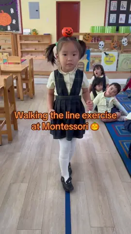🎃“Walking the Line” is a Montessori exercise that helps children develop balance, coordination, and concentration. In this activity, children walk slowly and carefully along a line, usually drawn or taped on the floor, often carrying an object like a small tray or balancing a beanbag on their heads. Here’s how it benefits the child: 	1.	Balance and Coordination: By focusing on steady movement and posture, children refine their motor skills and control over their body movements. 	2.	Concentration: The act of walking carefully requires focus, encouraging children to develop their concentration and mindfulness. 	3.	Self-Control: Walking the line helps children learn to manage their impulses and maintain control, an important aspect of self-regulation. 	4.	Inner Discipline: The exercise instills a sense of calm and order, as children practice repeating the activity with care and precision. 	5.	Grace and Courtesy: Walking the line often incorporates lessons in grace and courtesy, teaching children to move gracefully and interact gently with their environment. It is a foundational activity in Montessori that supports physical, emotional, and cognitive development.