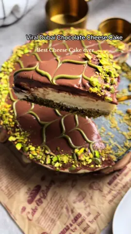 Viral Dubai Chocolate Cheese Cake✨ Ingredients Bottom layer: 400g Phyllo Dough 2 tbsp butter 1 1/2 cups pistachio paste 1-2 tbsp tahini Cheese Cake layer: 500g Cream Cheese (I used mascarpone room temp) 150g Condensed milk  200ml Double Cream 1 tsp vanilla extract Ganache: 80ml Double Cream 200g milk/dark chocolate ( I used 50/50) Method Start by shredding phyllo dough, add butter to a pan now toss the phyllo dough until golden and crispy. Let cool for a bit then add tahini and pistachio cream, mix well. In a bowl add cream cheese and condensed milk, beat until smooth, then add double cream and vanilla beat until stiff peak.  Make the ganache by adding chocolate to hot cream, cover and leave for 5 mins then stir until smooth. Assemble: To an 8’’ pan add the phyllo dough mixture press down with a spoon or cup. Now add cream cheese mixture and finally top with ganache. Refrigerate 6-8 hrs or overnight  Garnish with pistachios  Follow for more delicous recipes #viraldubaichocolate #dubaichocolate #dubaichocolatecheesecake #nobakecheesecake #cheesecake #nobake #fixchocolate #viral_video #fyp 