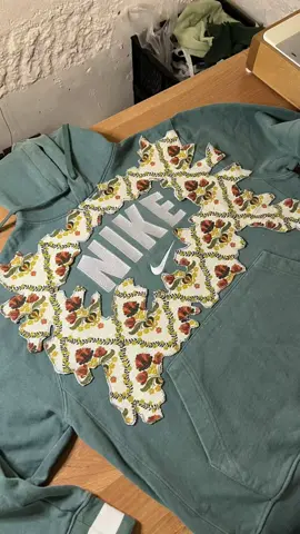 Upcycling Another Hoodie – Nike Edition! 🧵✨ First things first—check for any stains, holes, or other damage. Luckily, this hoodie was in great shape with no flaws, so I could go straight into designing! I took inspiration from my blue collection GAP hoodie (you can check that reel on my page). Although the logos were different sizes, I still had to freehand the pattern. Step 1: Measuring the Logo I started by measuring the Nike center logo and built the whole design around it. After sketching the design on paper, I traced the cutout onto my fabric and cut it out. I used an old thrifted hoodie as backing for the design fabric. Step 2: Preparing the Design I pinned the fabric design to the backing and sewed them together using a zigzag stitch to prevent fraying. Step 3: Attaching the Design Next, I pinned the completed design to the inner side of the hoodie and sewed around the edges. Then, I cut out the design from the good side of the hoodie, revealing the reverse appliqué magic. Voila! Step 4: Reworking the Sleeves Now for the sleeves! First, I ripped open the original seams to lay the arms flat. I followed the same process as with the chest—creating a design, backing it, and sewing it on. Once that was done, I reattached the sleeves with a mix of straight and zigzag stitches for durability.  sew upcycle rework repeat ♻️ • • • • • #reworkedclothing #reworkedclothes #reworkedfashion #reworkedvintage #sustainablefashion #1of1 #vintagenike #nikevintage #reworkedhoodie #nikesecond #nikethrift #reworked #upcycle #upcycled #upcycledclothing #upcycledfashion #upcyclefashion #SmallBusiness #howto #DIY #lifehacks #craftsmanship 