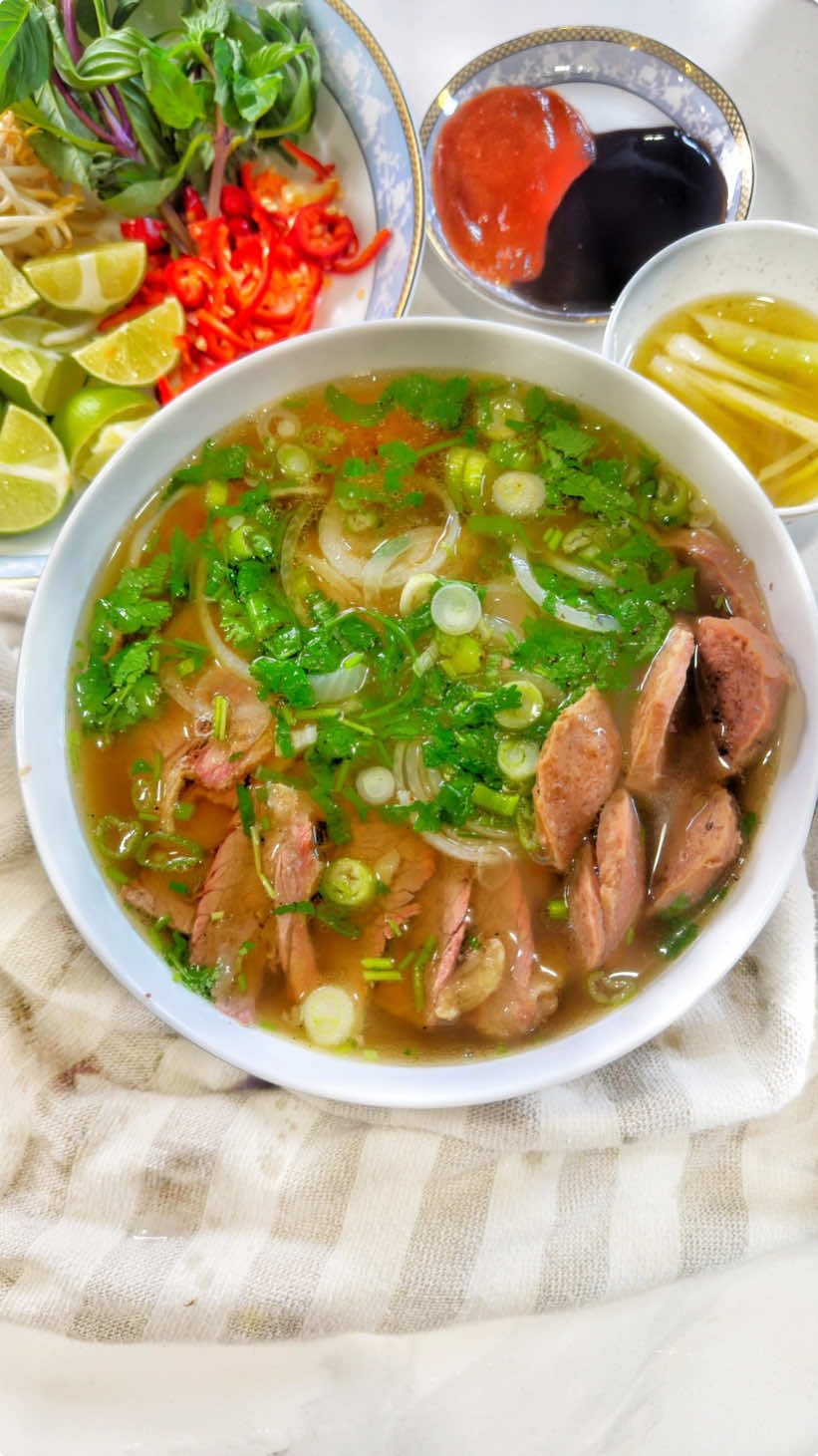 I’m all about sustainability in the kitchen & finding multiple uses for every ingredient.  I enjoyed a massive tomahawk steak & bone marrow from @Vue Prime Mexican Steakhouse (see previous post). Which I then repurposed & turned into BEEF PHO.  This recipe is inspired by BB sis @Jen Dao who also visited Vue & made Pho 🫰 INGREDIENTS: (10-15 servings)  - 16 quarts of water for pho broth (4 gallons)  - 1 gallon of water for brisket  - Beef bones & bone marrow (approximately 5-7Ibs)  - 1Ib of brisket  - 1.5Ib of beef eye round steak  - Beef meatballs as preferred  - 4 stocks of green onions - 2 large knobs of ginger (sliced)  - 5 yellow onions (halved)  - 2 shallots (halved)  - 2 large pieces of rock sugar  - 1.5 tbsp of MSG (optional)  - 1 1/4 cup of fish sauce  - 1/4 cup or granulated chicken bouillon - 2 tsp of salt  - Pho rice noodles  - Garnishes: Basil, green onions, white onions, cilantro, jalapeños, bean sprouts & lime  DRY AROMATICS  - 2 tsp fennel seeds - 2 tsp coriander seeds - 8pcs of whole cloves  - 6pcs of star anise - 3pcs of black cardamon  - 4pcs of cinnamon sticks  Fill the pot with 16 quarts of water and set on low medium heat. If you’re repurposing beef bones; rinse the bones of any seasonings & transfer onto a baking dish. Set the oven on low broil, transfer the baking dish into the oven and broil for 5 minutes. Remove from the oven & transfer the bones + drippings to the stock of water.  For uncooked bones; rinse, then set the bones onto a baking dish and massage with a bit of oil. Set the oven on 375 degrees and transfer the bones to the oven. Remove after 45mins then add to the stock of water.  Toast ginger, onions & shallots until slightly charred then transfer to the stock. For the dry aromatics; toast onto a pan on medium high heat for 2 mins. Transfer to a cheesecloth or steel basket, then add to the stock.  Add in rock sugar, MSG, fish sauce, chicken bouillon & salt.  Fill 1 gallon of water to another pot on high heat and add the brisket. Cook for 5 mins, remove from the pot & rinse under cold water. Transfer the brisket to the pho stock.  TIPS & MUST DO’S:  - After 2 hours, remove the spice basket from the broth - After 3.5-4 hours, remove the brisket and set into the fridge. Once fully cool, cut into thin slices - Impurities will float to the surface, remove this periodically with a mesh strainer  - At the last hour, add sliced beef balls & green onions  - Pho broth can be ready at the 10 hour mark, but best enjoyed between 18-24 hours. At this point you can add more fish sauce or rock sugar to taste.  Top it off with Nuoc Beo (fatty broth) your fav garnishes, hoisin, hot sauce & chili oil. My fav satay sauce of all time is by @Saigon Drip Cafe  it’s packed with heat and flavor!  #seattle #pho #vietnamese #Recipe 