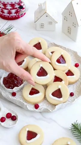 Santa Hats Cookies🎅🏼 (Nut-Free) You all wanted a nut-free cookie after the Ghost Cookie I posted, so here’s a simple recipe! Ingredients: •2/3 cup unsalted butter, softened •3/4 cup granulated sugar •2 vanilla beans, scraped •1 egg •2 1/4 cups all-purpose flour •1/4 tsp pink salt •Zest of 1 lemon or orange (optional) •Any flavor of jam, for filling  Method: 1.Cream the butter, sugar, and vanilla seeds until pale and fluffy, about 2-3 minutes. Add the egg and mix until well combined.  2.Gradually add flour and salt, mixing on low until combined. 3.Shape dough into a square, wrap, and chill for at least 30 minutes.  4.Preheat oven to 350°F.  5.Line cookie sheets with parchment paper. Roll dough between two sheets of parchment to 1/4 inch thickness.  6.Cut out cookies from the dough using a round cookie cutter, and place them on a parchment-lined cookie sheet 7.Using a heart-shaped cutter, cut the center out of half of the cookies. 8.Bake for 10 minutes.  9.Allow cookies to cool. 10.Once cooled, fill them with jam and use icing to create the white parts of Santa’s hat for a festive look. #cookies #christmas #recipes 