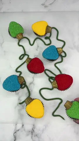 Twinkling lights ❤️💛💙💚 Have you turned your Christmas lights on yet? 💡🔛 I used mini cupcakes for these.  💛 Add different colours of buttercream in a triangular shape on top of the cupcakes.  ❤️ Press them into sanding sugar.  💚 Brush  mini Reese’s cups with gold lustre dust and attach them to the top (I cut them in half so they sat flush on the cupcakes)  💙 Use a dark green buttercream to pipe a squiggly line onto your serving board,  arrange the lights around the line. That’s it…. Enjoy 💛❤️💙💚 #cupcake #christmasbaking #cake #cakedecorating #cakedbyrach #cakeart #christmaslights #edibleart #minicake #cutefood 