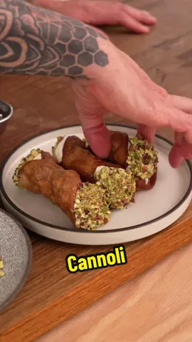 Cannoli Ingredients - 270g plain flour (ap flour) - 60g lard - 100g sugar - 2 eggs - 2 tsp cinnamon - 120ml red wine (sweet not dry) - 0.25 tsp vanilla paste - 2g salt - 500g ricotta - 1 lemon - 100g chopped pistachios - oil for frying Method 1. Place your flour and lard into a large bowl. Using a pastry cutter, two forks, or your fingers, rub the lard into the flour until you reach a sandy consistency and the lard is evenly distributed. 2. Add 50 grams of sugar, two egg yolks, a quarter teaspoon of cinnamon, the red wine, salt, and half of the vanilla extract to the centre of the bowl. Mix from the centre outward until completely combined. 3. Once you have a shaggy dough, turn it out onto a floured bench surface and knead for 3-4 minutes or until it becomes smooth and forms a clean mass. 4. Wrap the dough in cling film or plastic wrap and place it in the fridge to rest for two hours. 5. To make the ricotta filling, pass the ricotta through a fine sieve. Then add a quarter teaspoon of vanilla paste, the remaining cinnamon, the remaining sugar, and the zest of one lemon. Whip until smooth. Adjust consistency by adding lemon juice or milk as needed until it resembles thick whipped cream. Place in a piping bag and refrigerate until ready to use. 6. Once the dough has rested, remove it from the fridge and roll it out on a well-dusted bench to about 1-1.5 mm thick. Use a large cookie cutter to cut circles from the dough. Gather excess dough, if desired, to re-roll, though the quality may diminish slightly. 7. Roll each pastry disc individually to form an oval shape. Wrap each around a cannoli mould (wood or metal), sealing the edge with egg whites. Ensure it is wrapped loosely to allow for expansion in the oil. 8. Preheat frying oil to 180°C. Carefully place the cannoli in the oil, avoiding overcrowding. Fry for 5-6 minutes, until golden and crisp. Remove and drain on a wire rack, then allow to cool. 9. To serve, pipe the ricotta filling into the cannoli from both ends, dip the ends in chopped pistachios, and enjoy. #cooking #ricitta #italy 