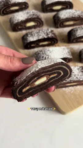 מגולגלות קינדר🍫 מצרכים🛒 420 גרם קמח (3 כוסות)  חצי כפית אבקת אפייה  50 גרם קקאו  100 גרם אבקת סוכר  קורט מלח  250 גרם חמאה קרה חתוכה לקוביות  2 כפות שמן  2 ביצים m 450 גרם ממרח קינדר  10 אצבעות קינדר  + אבקת סוכר להגשה  אופן ההכנה 👩🏻‍🍳 מערבבים במעבד מזון/ מיקס וו גיטרה, את הקמח, אבקת אפייה, קקאו, אבקת סוכר, חמאה ומלח, עד לקבלת פירורים. אח״כ מוסיפים שמן וביצים, ומערבבים רק עד קבלת בצק ולא מעבר. אם הבצק נוח לעבודה, אפשר ישר להתחיל לרדד, אם לא,  עטפו את הבצק והכניסו למקרר ל20 דקות (אני לא עושה את זה, אני ישר מרדדת, הוא יוצא מספיק נוח). מחלקים את הבצק ל2 חלקים, מרדדים כל חלק בין 2 ניירות אפייה. מורחים את ממרח הקינדר,  מסדרים אצבעות קינדר בקצה ומגלגלים בעזרת נייר האפייה. מכניסים ל20 דקות למקפיא, בזמן הזה מחממים תנור ל170° חום עליון תחתון. לאחר מכן אופים 20 דקות, ולאחר האפייה מכניסים למקרר לשעתיים (כדי שהחיתוך אח״כ יהיה יפה ומדוייק). לאחר הקירור, חותכים פרוסות, מפדרים אבקת סוכר ובתאבון 🩷