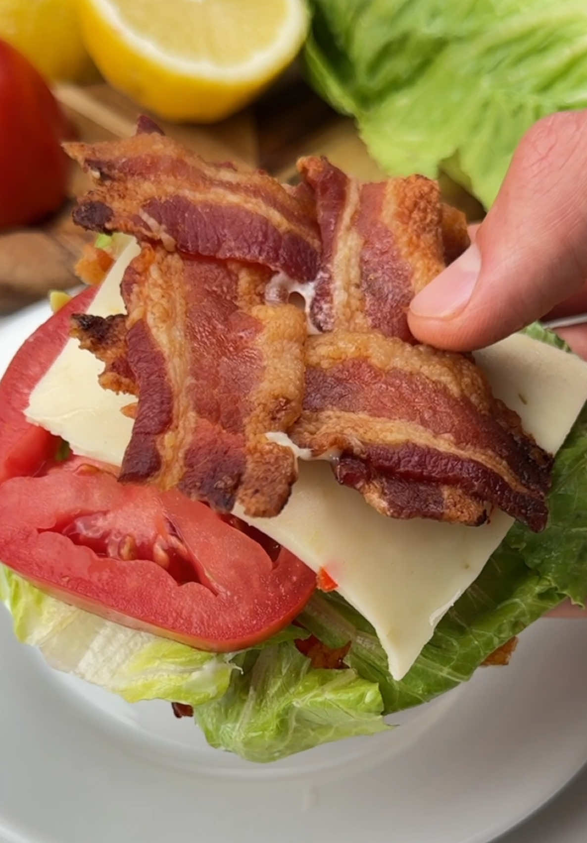 Say “YUM” if you would eat this Bacon Bun BLT Sandwich 🥓🥬🍅 How to make it: 1. Cut a few bacon slices in half and weave together into squares. 2. Bake @ 375F for 30 mins.  3. Add lettuce, avocado, tomato, cheese and ranch or mayo.  4. Enjoy!