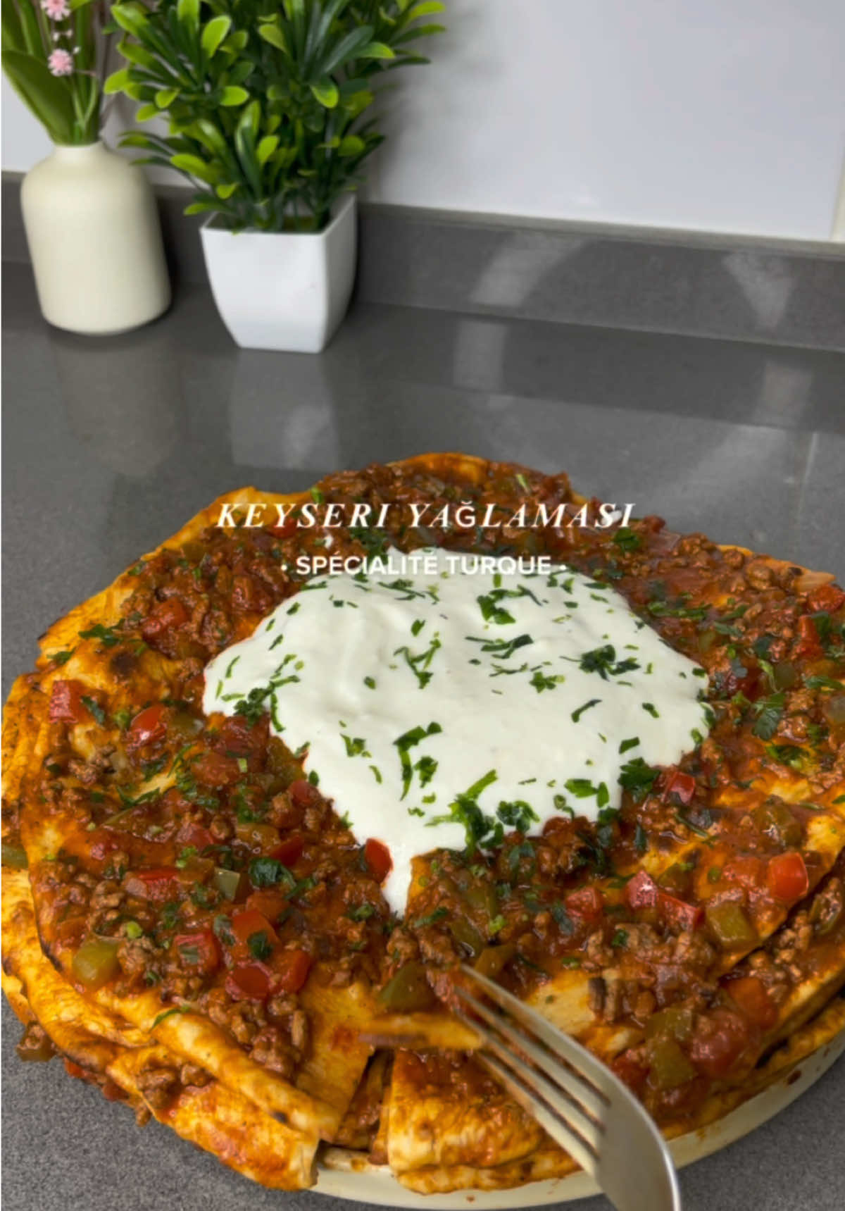 Aujourd’hui c’est keyseri yaglamasi 🇹🇷  c’est une spécialité turque à base de viande hachée en sauce, c’est tellement bon 😋 INGRÉDIENTS (pour avoir 5 étages, pour environ 4/5 personnes) Pour les pains/wrap 🫓 : - 2 grands verres de farine - 1/2 verre d’eau 💧  - 1/4 verre de lait 🥛  - levure sèche - un tout petit peu de sucre (facultatif) - sel 🧂 Pour la farce : - 350g de viande hachée 🥩  - 1 gros oignon 🧅  - 1 poivron rouge et 1 poivron vert 🫑  - pâtes d’ail ou 2/3 gousses d’ail 🧄  - 1 boite de concassé de tomate ou 4 tomates mixées 🍅  - 2 càs de tomates concentrées  - paprika, poivre et sel - une bonne dose de beurre 🧈  🍶 Pour la sauce au yaourt, prenez du yaourt mettez 2 gousses d’ail, un peu de sel et du citron par exemple. Vous pouvez mettre de la menthe ou du persil #keyseriyağlaması #turkishfood #cuisineturque #turquie #cuisinedumonde 