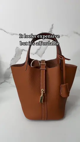 Looking oddly familiar 🤫👀Loveee it#bag#leatherbag#handbag#tote #lockdesign #stylish#afforableluxury #brown#elegant#bucketbag#women#stylishonbudget#tiktokshopcybermonday #spotlightfinds #chrismas#elegant