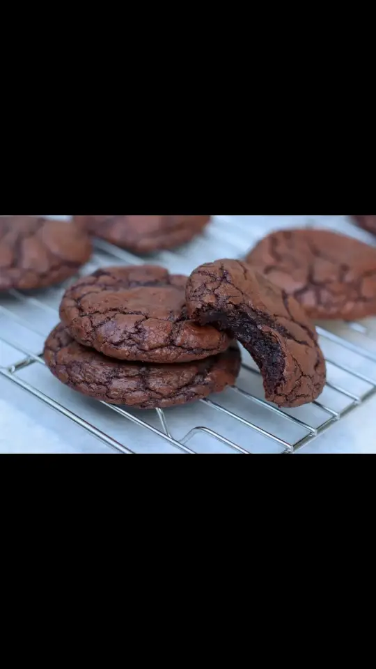 Preheat oven to 350 F Prepare baking sheet with parchment paper  3/4 cup finely chopped semisweet chocolate  1/2 cup unsweetened cocoa powder 1 tsp espresso powder 1/2 cup unsalted butter 2 large eggs - room temp 3/4 cup sugar 1/2 packed dark brown sugar 1 tsp salt 2 tsp vanilla 3/4 cup flour Flaky seas salt/finishing salt In a heatproof bowl, add chocolate, cocoa powder, and espresso powder.  In a saucepan, melt butter over medium-low heat until bubble, about 3 minutes. Do not let brown.  Pour melted butter over chocolate mixture. Let sit so the chocolate softens  In a electric mixer bowl, add eggs, both sugars and salt. Using whisk attchment, whisk on medium high speed until mixture is fluffy, about 3 - 5 minutes Stir the chocolate mixture until smooth.  With the mixer on low speed, add the vanilla and then the chocolate mixture. Scrape the sides and the bottom of bowl to make sure the chocolate is evenly distributed, then add the flour and mix on low speed. Dont over mix. Use spatula to finish folding in the flour. The dough should be be shiny and look like thick brownie batter.  Using small icecream scooper, scoop dough into mounds and place on baking sheet.  Bake for 8 minutes until cookies start to soread and have a shiny outer surface. Remove from oven and slam on counter a couple times to create cracked surface on top of cookies.  Top with flaky sea salt and return to oven to finish baking for another 2 minutes until slightly puffed.  Cool for a couple minutes on baking sheet before transferring to wire rack to cool completely.  #brownies  #cookie  #chewychocolatecookies  #chocolate  #desserts 