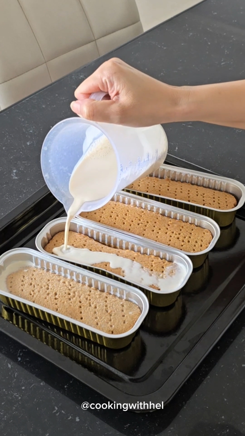 Hai... kali ini Hel buat milk bath cake versi tiramisu. Kombinasi cake rasa kopi dengan siraman susu dan cream tiramisu. Untuk cream resepnya sama persis dengan resep no flour choco tiramisu yang barusan saya share ya, cuma saya buat separuh resep. Tiramisu milk bath cake By @CookingwithHel   Bahan cake / bolu kopi - telur 2 butir - sp / tbm ¼ sdt - pasta vanila ½ sdt - gula 40 gr - terigu protein sedang 50 gr - kopi instan 2 gr - butter leleh 50 gr oven suhu 175 °C 15 menit, oven sudah dipanaskan sebelumnya. - siraman: susu evaporasi secukupnya (per cup saya tuang sekitar 50 ml). Ini bisa dikombinasi dengan whipped cream cair kalo suka yang lebih creamy ya Bahan cream versi 2 telur Bahan: - kuning telur 2 butir - gula halus 30gr (bisa pakai gula pasir yg diblender) - pasta vanila ½ sdt - cream cheese / keju spread 100gr - whipped cream cair 200ml (dingin kulkas) Cara buatnya bisa cek video no flour choco tiramisu dessert box Cara buat bisa dilihat di video #milkbathcake #tiramisumilkbathcake #resepmilkbathcake #tiramisu #dessertbox #idejualan