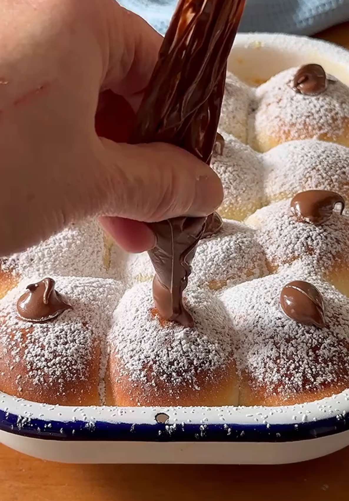 מיני סופגניות שוקולד אפויות 🍫 הכי טעימות שילדים אוהבים! קטנות, מדהימות, ומלאות במילוי מפנק. הטיפ שלי: מכינים בצק כפול – חצי מטגנים, חצי אופים, וכולם מרוויחים. מושלמות כשהן יוצאות חמות, ונחטפות תוך שניות! מי מנסה להכין אותן כבר היום? פוסט מתכון חשיתוף ושמירה📌📌 לתבנית בגודל כ 20*25 ס״מ לבצק 250 גרם קמח 2/3 1 כוסות( מומלץ קמח עשיר בגלוטן) 1/2  כפית שמרים יבשים או עף חצי טריים 1/2 כוס חלב  רגיל או צמחי( 120  מ״ל) 1 ביצה 4 כפות סוכר קורט מלח 20 גרם חמאה מומסת או שמן למילוי 2/3 כובס ממרח שוקולד שאוהבים 1 ביצה טרופה להברשה 2 כפות אבקת סוכר  ההכנה 1. מניחים את מרכיבי הבצק בקערת מיקסר עם וו לישה. מקפידים שהמלח והחמאה לא יגעו בשמרים. לשים 2 דקות במהירות נמוכה. בודקים את הבצק ובמידה והוא יבש מידי מוסיפים קצת חלב ואם הוא רך מידי מוסיפים מעט קמח. ממשיכים ללוש 10 דקות עד שהבצק אחיד ואלסטי. מכסים ומתפיחים כשעה או עד שהבצק מכפיל את נפחו. 2. על משטח מקומח מרדדים את הבצק למלבן בעובי כ 1/2 ס״מ. מחלקים ל 12 ריבועים שווים בכל ריבוע מזלפים או מניחים כפית מהמילוי. סוגרים היטב את 4 הפינות לכדור. מניחים על תבנית מדומנת ומרופדת בנייר אפייה. 3. מתפיחים מכוסה כ 45 דקות או עד שהבצק כמעט והכפיל את נפחו. מברעשים בביצה. 4. אופים כ 20 דקות או עד שנזהיב. מקשטים באבקת סוכר ועוד מהמילוי במרכז כל סופגניה. מגישים חמים. #שבתשלום #חנוכה #סופגניות #jewishfood  #chanukah