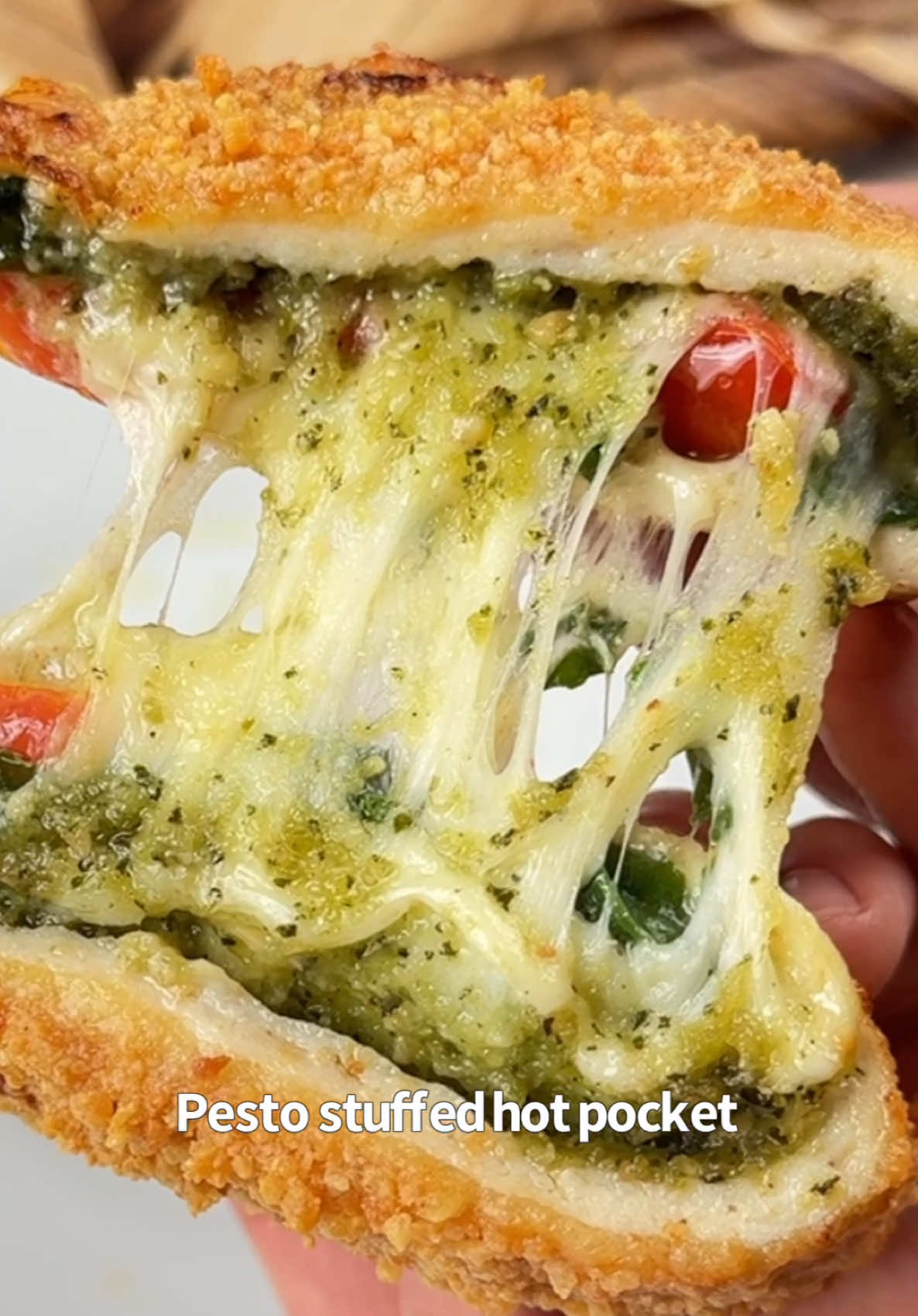Say “YUM” if you would eat this Pesto Stuffed Hot Pocket 😋🍅🌿  How to make it: 1. Flatten 3 oz ground chicken into a circle on greased parchment paper.  2. Add 1 tbsp pesto, 2 slices of mozzarella, a handful of chopped spinach & a few diced grape tomatoes. 3. Fold it over and seal the edges. Coat with egg wash and parmesan.  4. Air fry @ 400F for 10-12 mins. Take it out & enjoy!