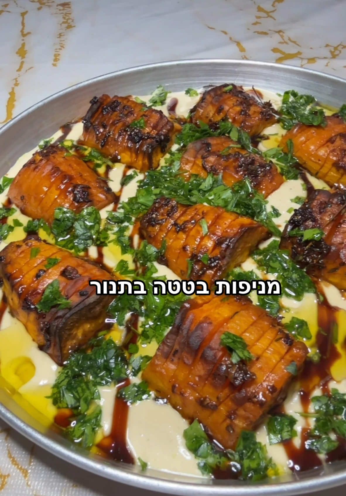 מתכון למניפות בטטה בתנור : -2 בטטות גדולות ‏-4-5 עלי טימין -4 שיני שום כתוש -1/2 כפית צ׳ילי גרוס  -2 כפות סילאן  -כפית מלח גס -1/2 כפית פלפל שחור גרוס -שמן זית בנדיבות   להגשה : טחינה גולמית  סילאן פטרוזיליה קצוצה דק אופן ההכנה : -מקלפים את הבטטות וחוצים ל2. חותכים ל3 חלקים ובעזרת סכין חדה פורסים את הבטטה כמעט עד הסוף , בשביל ליצור מניפה  . -מסדרים את הבטטות על תבנית עם נייר אפייה.  -בקערה קטנה שמים את כל מרכיבי התיבול ומערבבים היטב , מזלפים בנדיבות על הבטטות ומברישים היטב. -מחממים את התנור מראש על חום של 180 מעלות טורבו או בנינג׳ה על מצב צלייה. -מכניסים לתנור במשך 20-30 דקות או לנינג׳ה למשך 15 דקות ,עד שהן מתרככות ומעט משחימות. -לוקחים צלחת הגשה ומורחים שכבה של טחינה ומעל מזלפים סילאן , לאחר מכן מניחים את מניפות הבטטה ,מפזרים פטרוזיליה קצוצה ומזלפים מעל הכל שמן זית ומגישים . בתאבון. #בטטה #מתכון #מתכונים #מנתאירוח #מניפותבטטה #מבשלים_עם_טיקטוק #מבשליםעםאסתי #קללהכנה #מתכונים #חנוכה2024 #בטטותבתנור #טחינה 