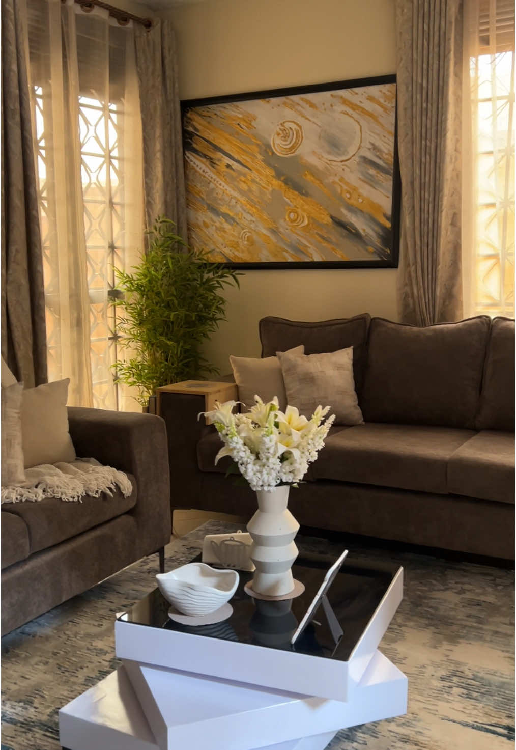 We transformed this gem in waiting of a living room into a cozy and chilll space with 4 simple upgrades.  ✨For the ultimate relaxation-New, comfy 3 - seater couches.  ✨To brighten up the room and magnify the space - A statement mirror.    ✨To add personality and style - floating shelves.  ✨And finally… To ground the space - A soft, warm rug.  Loving how this makeover turned out!  ✨✨Have a space that needs a facelift? Say no more! We’d love to help. +256776311982 or info@xquisdesign.org for inquiries.  #LivingRoomMakeover #CozyVibes #HomeTransformation #InteriorDesign