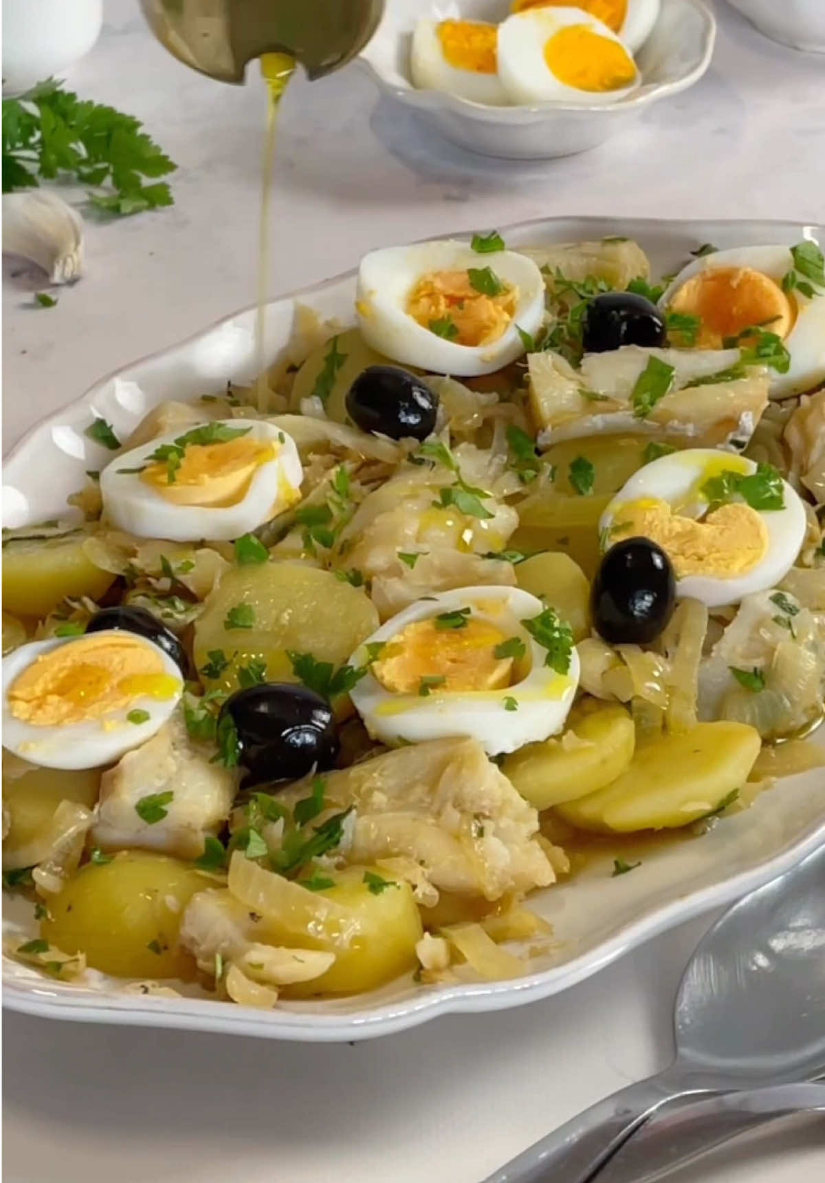 Bacalhau à Gomes de Sá, versão mais saudável com menos gordura. Este ano quebrei a tradição e não fiz Roupa Velha com as sobras da consoada, este ano foi Bacalhau à Gomes de Sá! A família agradeceu a iniciativa 😉😅 A verdade é que não tinha muitas sobras. O bacalhau da consoada estava ótimo, bacalhau da Noruega nunca nos deixa ficar mal, todos comemos muito bem. Assim, precisei cozer ovos para fazer uma nova refeição. Ingredientes * 1 e 1/2 posta de @bacalhaudanoruegaportugal (usei o que sobrou da consoada) * 2 cebolas * 3 dentes de alho * 2 folhas de louro * 4 batatas (o que sobrou da consoada) * 3 ovos * 1 + 1/2 colher de sopa de azeite * Sal * Salsa * Azeitonas Confecção 1. Cozer os ovos. 2. Lascar o bacalhau. Pelar e cortar as batatas às rodelas. 3. Fazer um refogado com 1 colher de sopa de azeite, cebola cortada em meias luas, o louro e alho picado. Refogar bem até a cebola começar a ganhar um bocado de cor. Adicionar um pouco de água e sal (eu não tinha a água de cozedura do bacalhau, se tiverem, devem usar). 4. Ferver até o líquido reduzir e a cebola estar completamente mole. 5. Juntar o bacalhau, batatas e salsa picada. Envolver. 6. Passar para a travessa, decorar com os ovos partidos em rodelas, azeitonas e o azeite restante. #bacalhaudanoruega #partilhaonatal #bacalhau #bacalhauàgomesdesá #receitadebacalhau #desperdíciozero 
