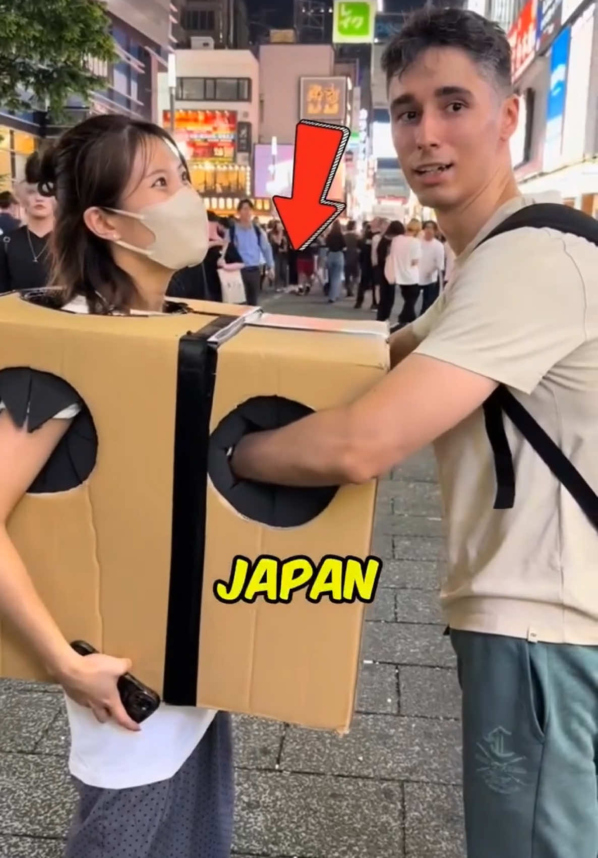 Japan Mystery Box 😱 Look, in Japan, girls carry a big box with two holes, where people can stick their hands. But why is she letting this happen? What's inside the box that makes people react so intensely? It's almost like they're trying to find something. She offers this activity to anyone, inviting them to reach in and feel what's hidden within. so what could be inside? #japan #mystery #girl #fyp