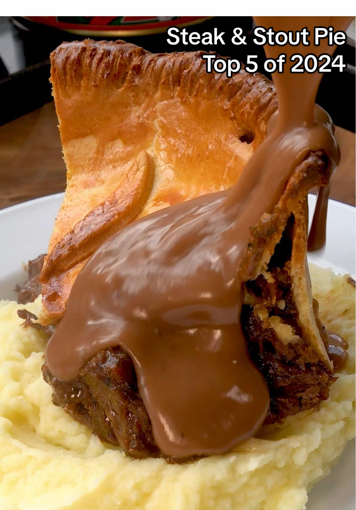 Steak & Stout Pie - My Top 5 recipes of 2024 - No.2 Recipe for Steak & Stout Pie with Mash & Gravy Ingredients (Serves 4): 800g shortcrust pastry plain flour for dusting  1 free-range egg, beaten 3–4 tbsp vegetable oil 900g Lean stewing steak pieces - @macburnhamfamilybutchers  2 onions, chopped 2 celery sticks, chopped 4 garlic cloves, chopped 1 fresh thyme sprig 2 bay leaves 300 ml Beef stock 400ml stout 2 large carrots, chopped  salt and pepper 1.2 kg Maris Piper Potatoes 100g Unsalted Butter 100ml Milk Salt & pepper 50g Butter 50g Flour 150ml Red wine 350ml Beef stock Method: Heat olive oil in a large ovenproof casserole dish. Brown the seasoned beef in batches, then set aside. Reduce heat, cook onions, celery, and garlic until softened around 8-10 mins. Return beef to the pan, add thyme, bay leaves, and stock. Add stout and carrots, bring to a boil, then cook in the oven until beef is tender, about 2–2½ hours at 150C. Adjust seasoning and cool. Prepare pastry base: line the pie dish with shortcrust pastry, blind bake with baking beans for 15 mins at 200C, then remove and bake a few more minutes. Once cooled carefully tidy up the edges with a sharp knife. For the mash, peal and chop your potatoes into medium chunks, boil potatoes in salted water until fork-tender, then mash or put through a potato ricer. Melt butter in a pan with milk and add to the mash. Then season to taste. Transfer filling to pastry-lined dish. Preheat the oven to 200C. Brush beaten egg around pastry edge, place pastry lid on top, seal, trim, crimp edges with a fork, and create steam vents. With any leftover pastry finish your pie with something decorative. Brush the top with remaining egg wash. Bake the pie for 30–35 minutes until golden and crisp. For the gravy, melt butter in a pan and add flour, cook for 2 minutes remembering to keep stirring then add red wine (this will thicken a lot) then whisk in stock. Season to taste. Serve the pie on top of the mash and pour over your gravy. Enjoy! #pubfood #britishfood #british #ukfood #series #pubgrub #pie #steakandstoutpie #steakpie #meatpie #gravy #mash 