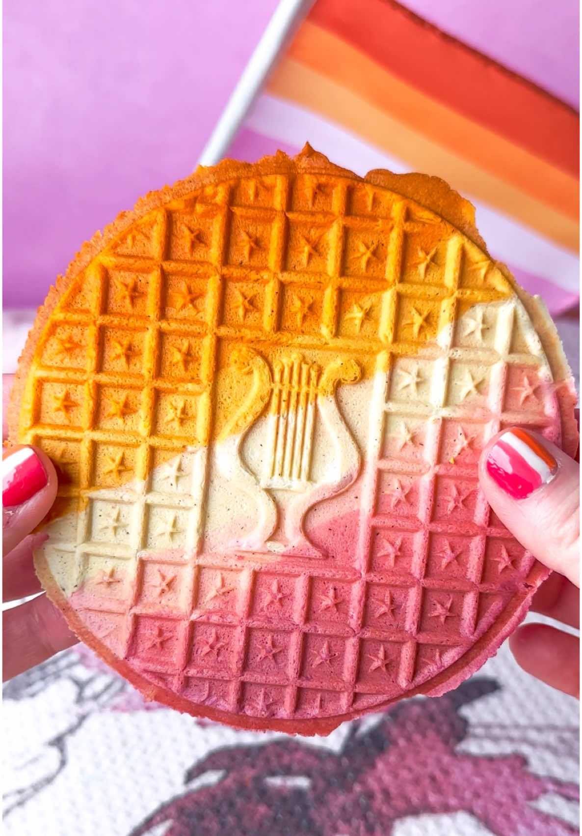 Lesbian Pride Pizzelle 🧡🤍🩷 PIZZELLE  225g AP flour 1/2 Tbsp baking powder 3 large eggs 150g sugar 88mL canola oil 1 Tbsp vanilla paste  1/4 tsp cinnamon Sift flour and baking powder together. Set aside.  In a mixer fitted with a paddle attachment, beat eggs at med speed. While continuing to mix, slowly add sugar (making sure the last bit was incorporated fully before adding more). Continue to mix and slowly add canola oil, vanilla paste, and cinnamon.  Continue to mix, and slowly add flour mixture. Mix until combined and smooth.  Preheat the pizzelle iron. Transfer batter into a large piping bag and cut a hole in the tip. When the iron is preheated, pipe a dollop of dough into the center of each mold. Close and cook for 15-45 seconds (time varies based on iron). Remove the cookies using a wooden chopstick and place on a cooling rack.  Once your cookies have cooled, lay them on a cookie sheet and bake at 220F for 30 min. (This will ensure they remain crispy). #wlw #wuhluhwuh #pizzelle #cookies 